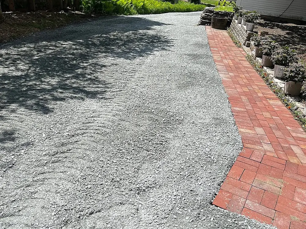Fresh gravel driveway with brick apron